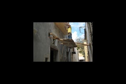 Crete scaffolder on precarious scaffolding